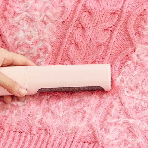 Fresh Sweep fabric hair-removal brush shown across a pink knitted textile